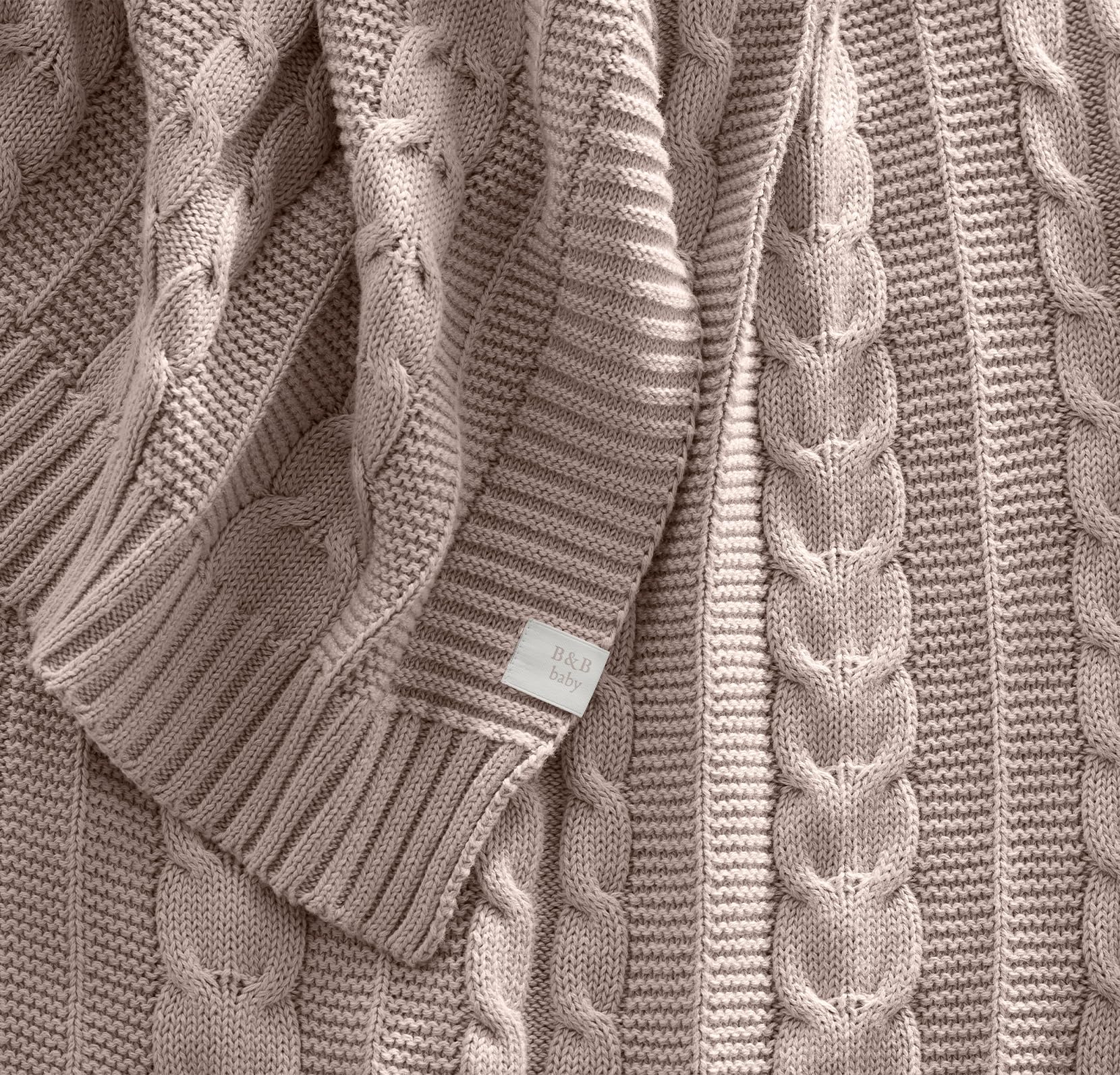 Close-up of the cable knit texture, showcasing organic cotton softness.