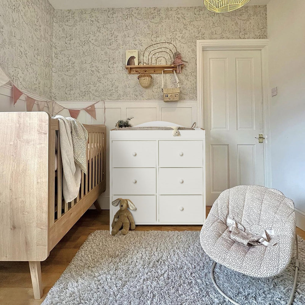 Six fabric drawers provide organized storage for baby essentials.