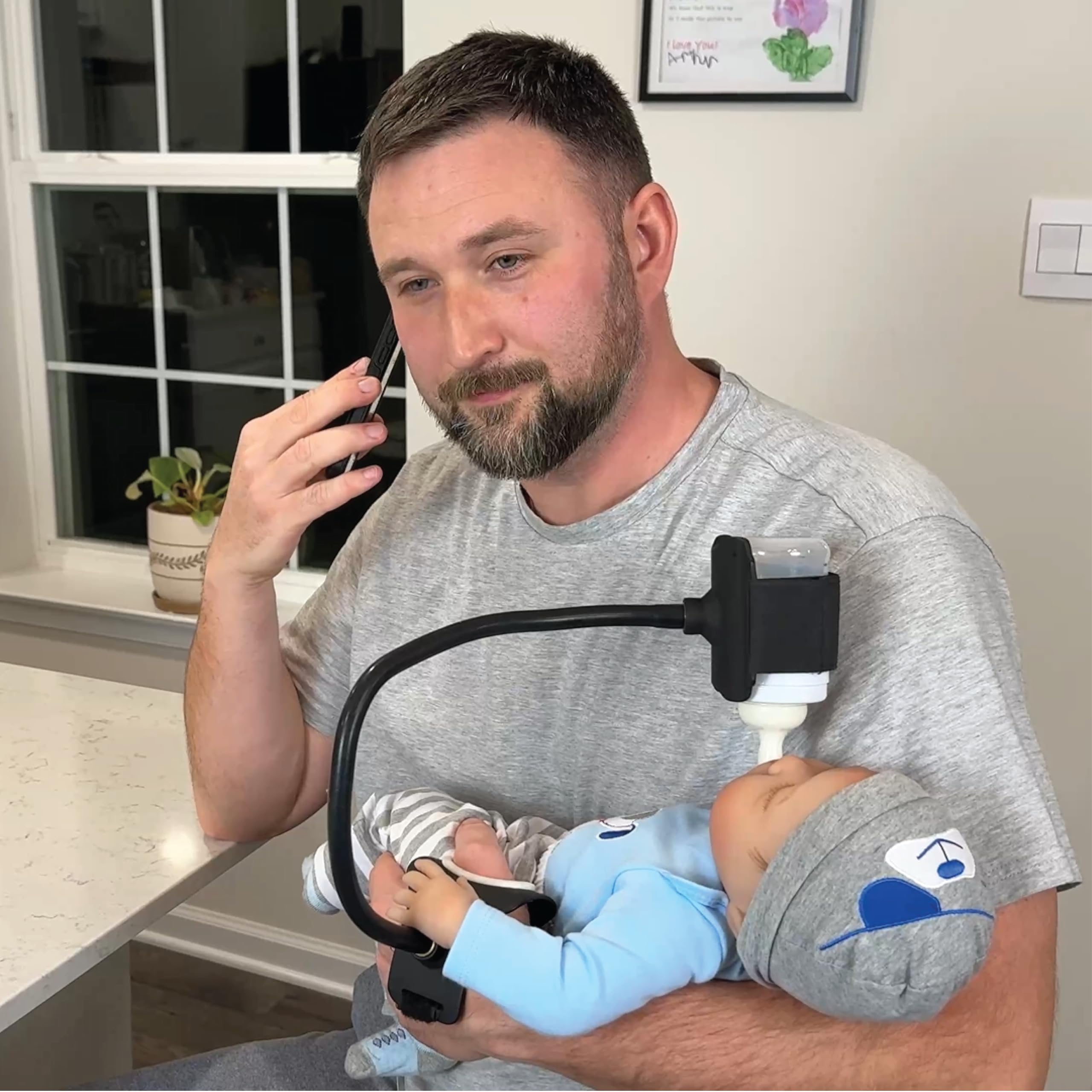 BOTTLESBUDDY baby bottle holder on wrist strap for hands-free feeding.