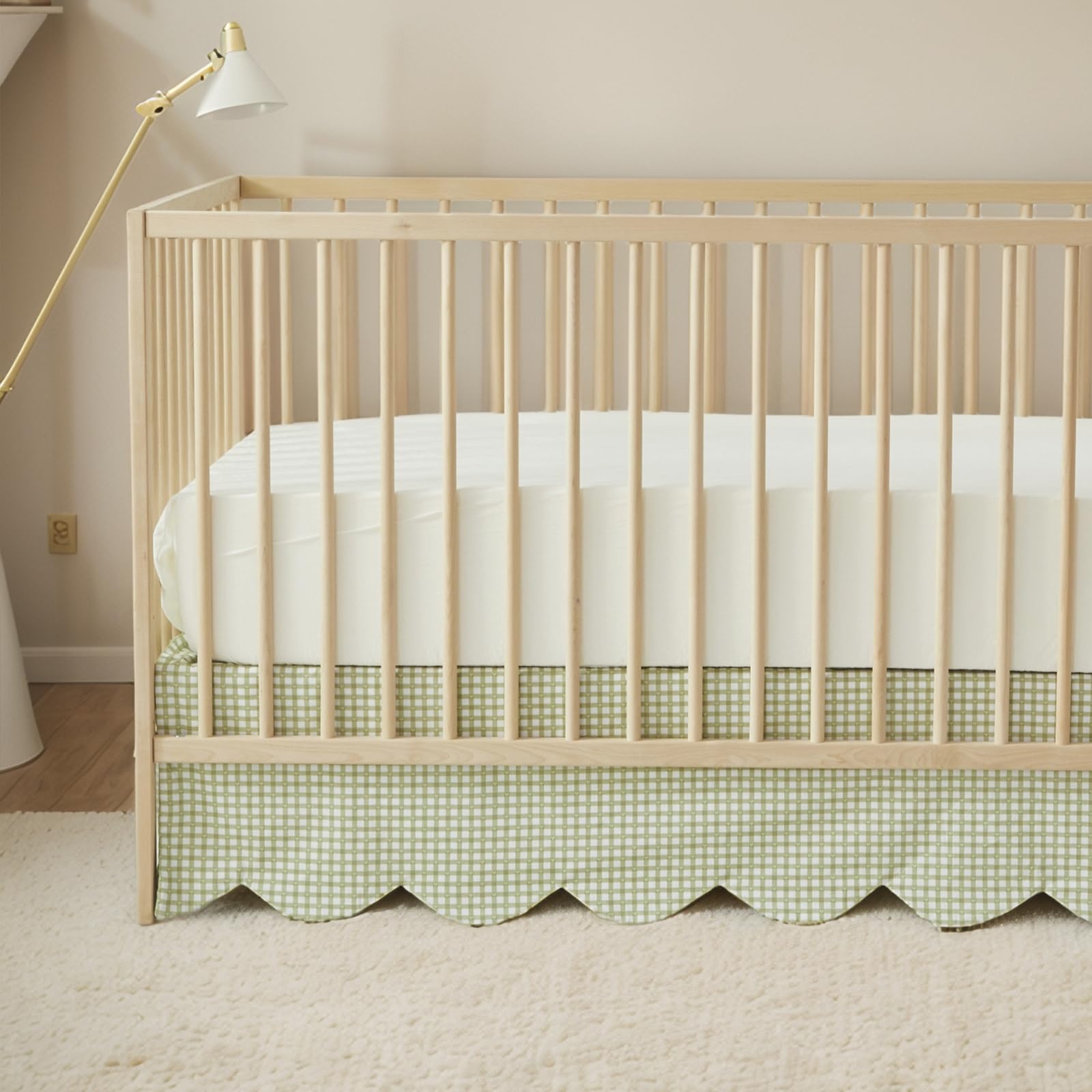 Brandream scallop-edge crib skirt in green gingham adds elegant nursery detail.