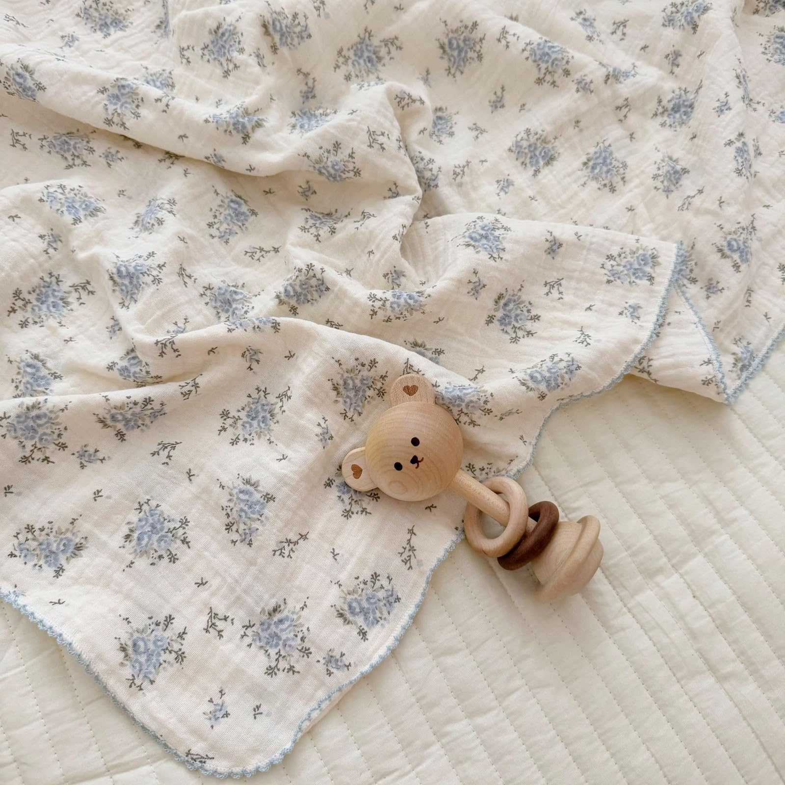 BuLuTu blue-floral muslin blanket folded highlights generous size for snuggling.