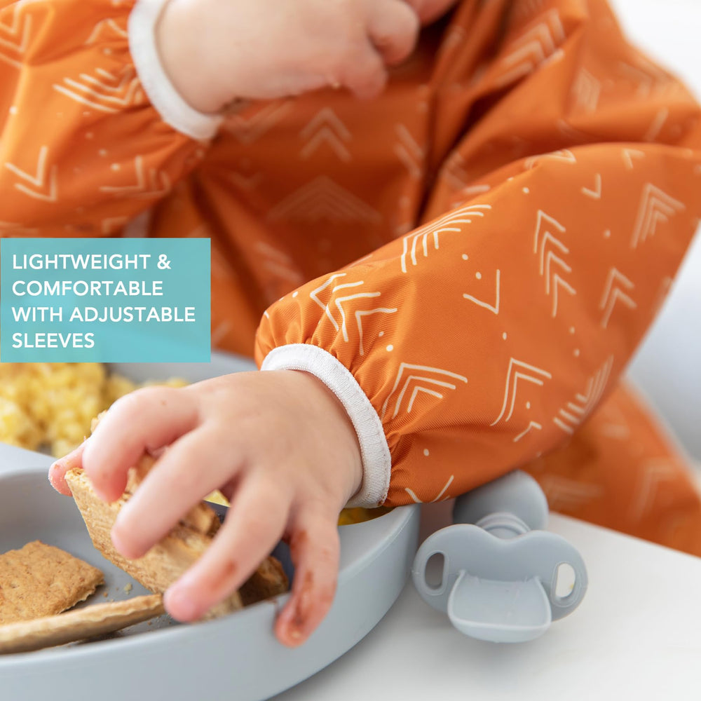 Bumkins Sleeved Bib Boho Orange elastic cuffs offer flexible arm coverage.