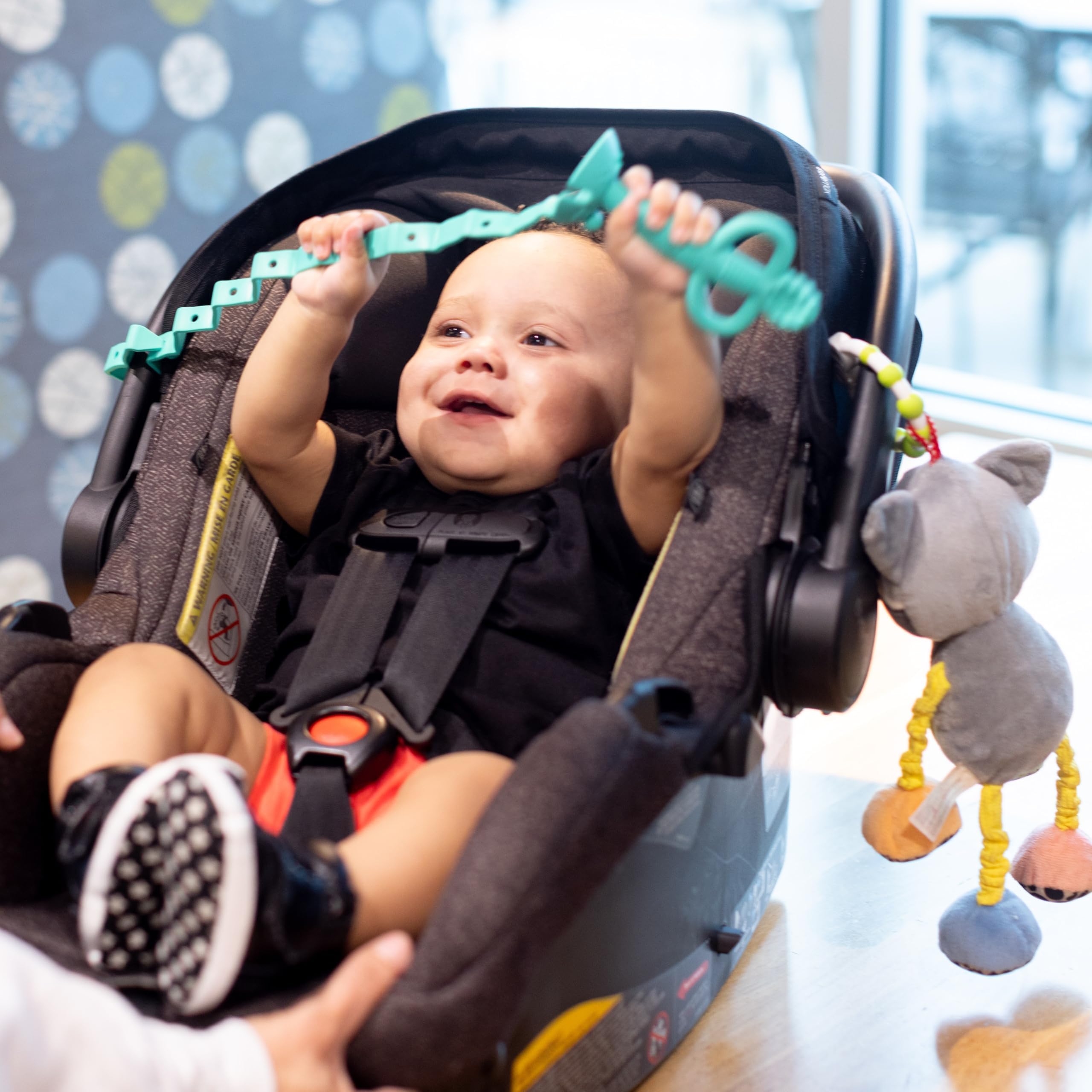 Busy Baby Toy Bungee attached to a stroller for convenient on-the-go play.