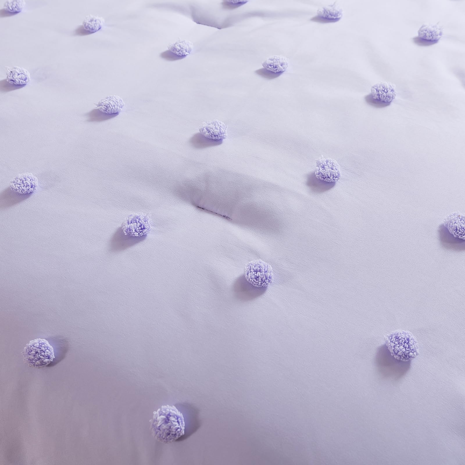 Caressma lavender comforter detail shows soft tufting texture.