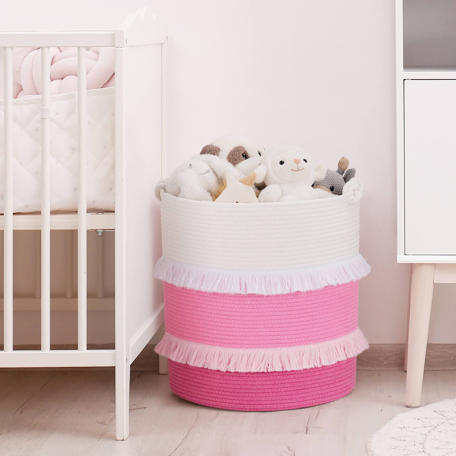 CherryNow nursery decor basket with pink tassels enhances girl's room ambience.