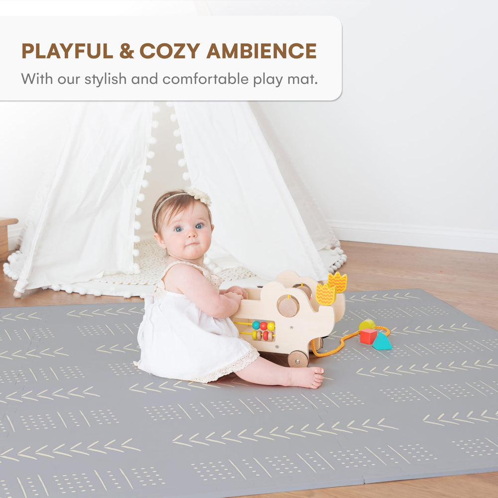 Childlike Behavior tummy time layout on a large grey mat for early movement.