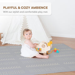 Childlike Behavior tummy time layout on a large grey mat for early movement.