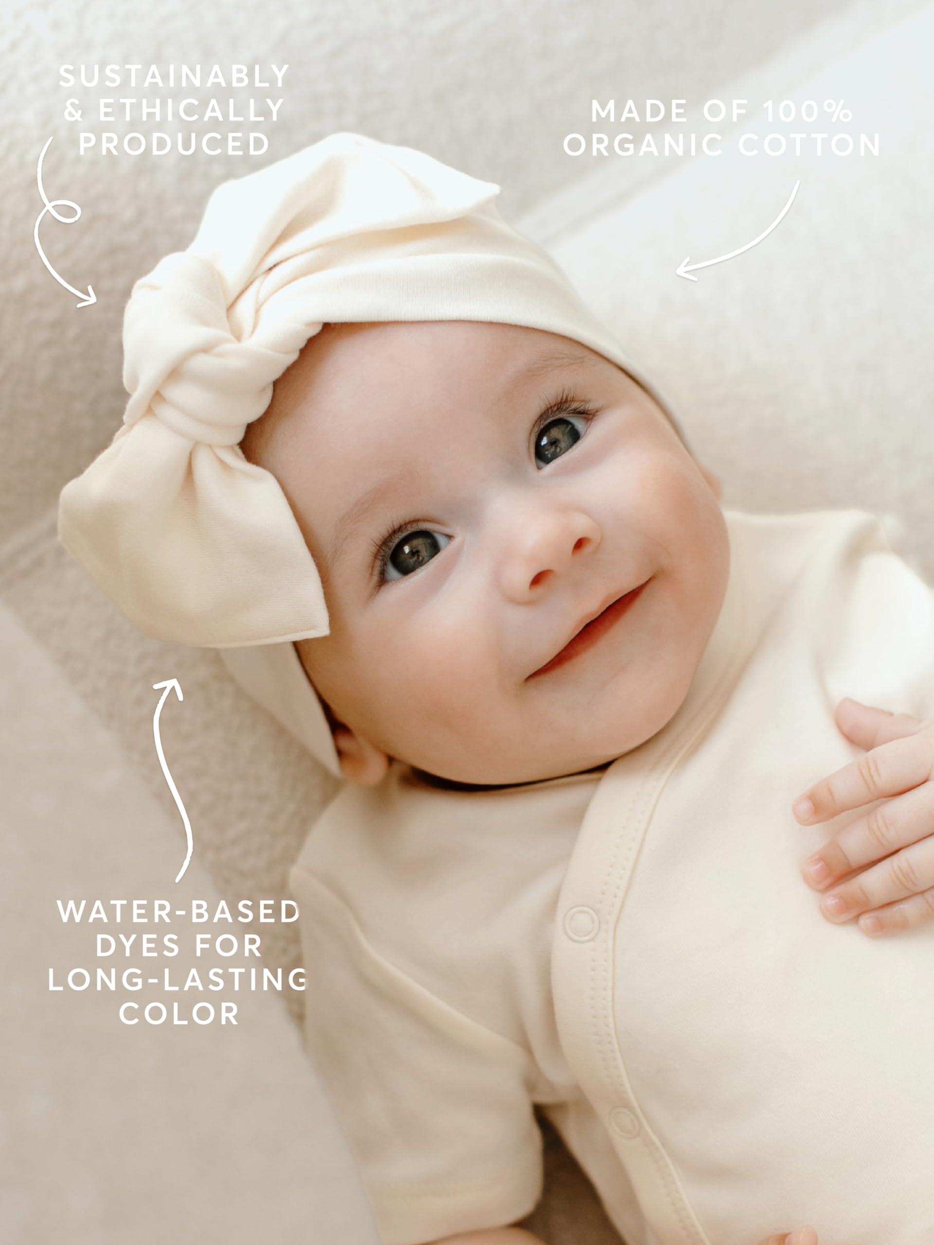 Colored Organics baby bow wrap on a smiling infant, cozy and breathable.