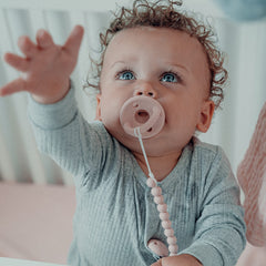 Comfy Cubs pacifier clip attached to baby clothes for on-the-go convenience.