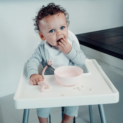 Comfy Cubs soft, lightweight pacifier clip rests on baby's clothing.