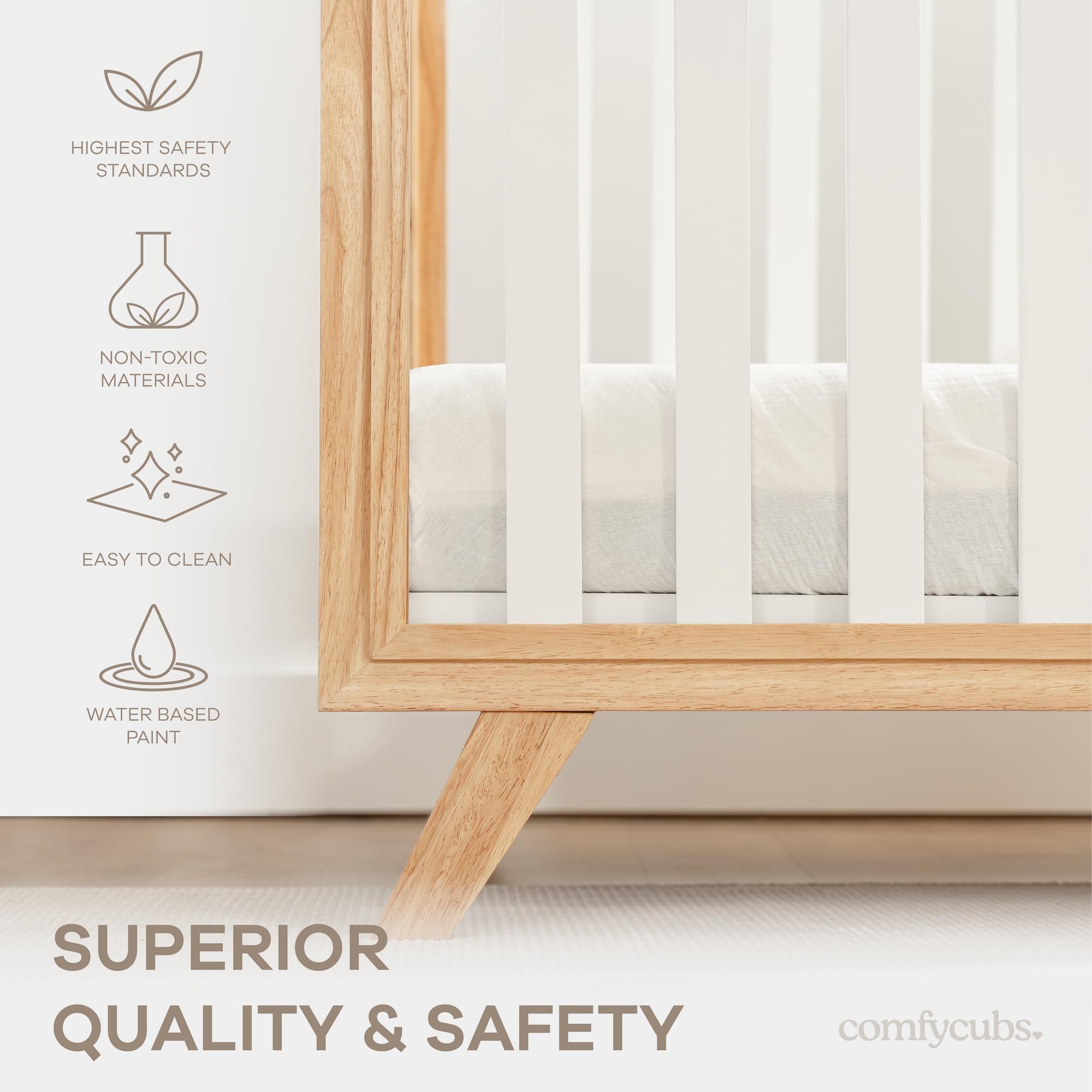 Crib with white bars and natural wood legs by Comfy Cubs in a cozy nursery