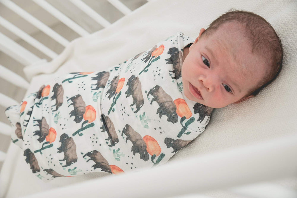 Copper Pearl bison-pattern blanket styled as a versatile receiving wrap for home and travel.