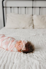 Copper Pearl Classic Baby Bow London pairs with Copper Pearl swaddles for a coordinated look.