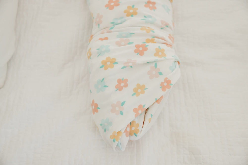 Copper Pearl Daisy swaddle blanket worn as baby wrap during cuddles.