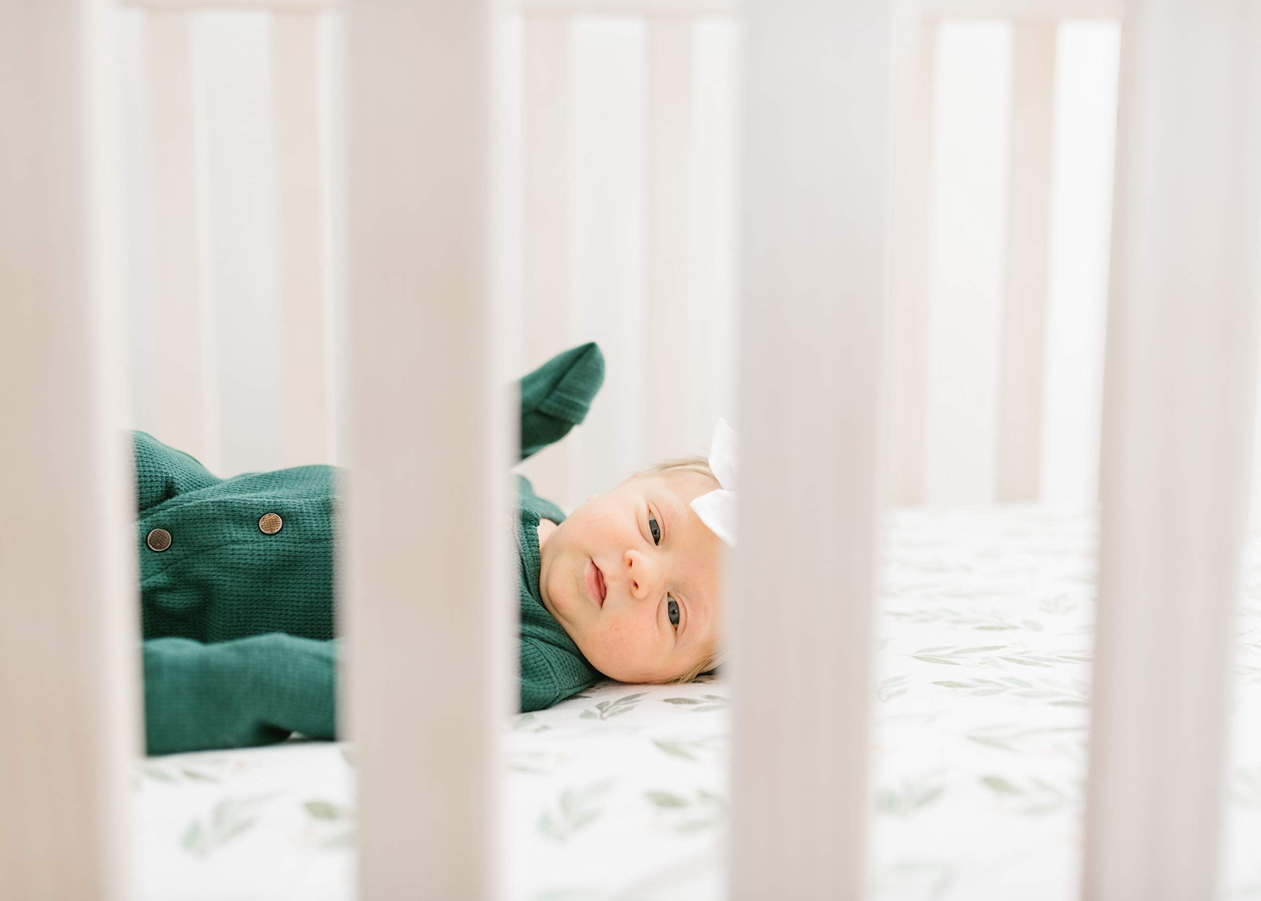 Soft scene of Copper Pearl fern knit crib sheet in a cozy crib for restful sleep