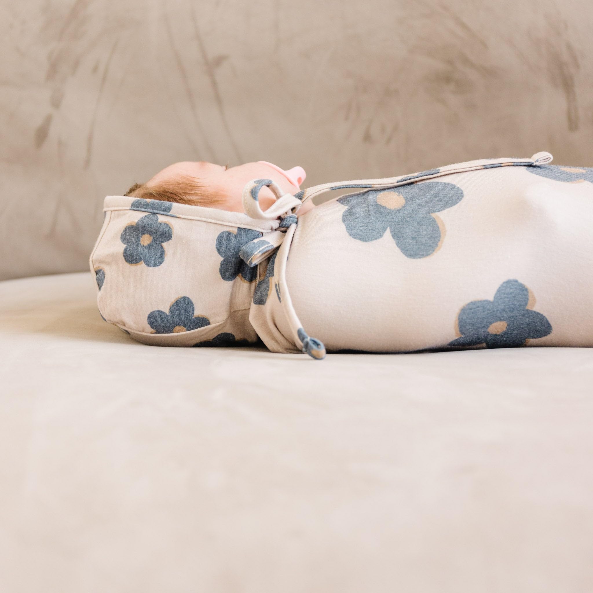 Copper Pearl Gemma Tan swaddle blanket folded for compact storage and travel convenience