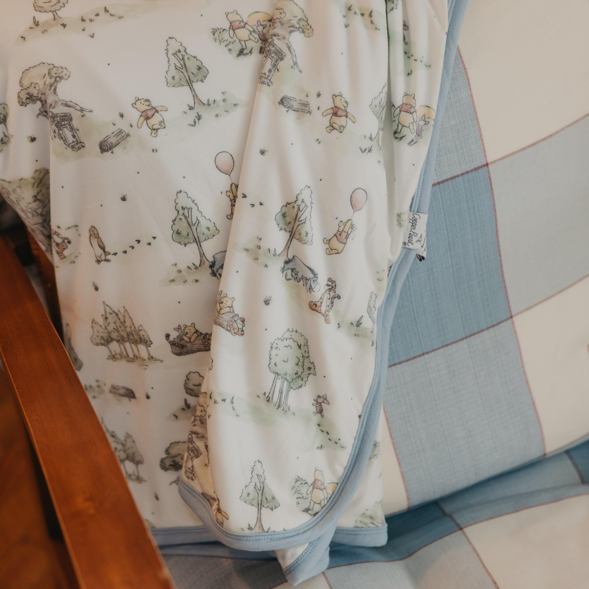 Copper Pearl Hundred Acre Wood quilt folded, ready for nursery storage or gifting
