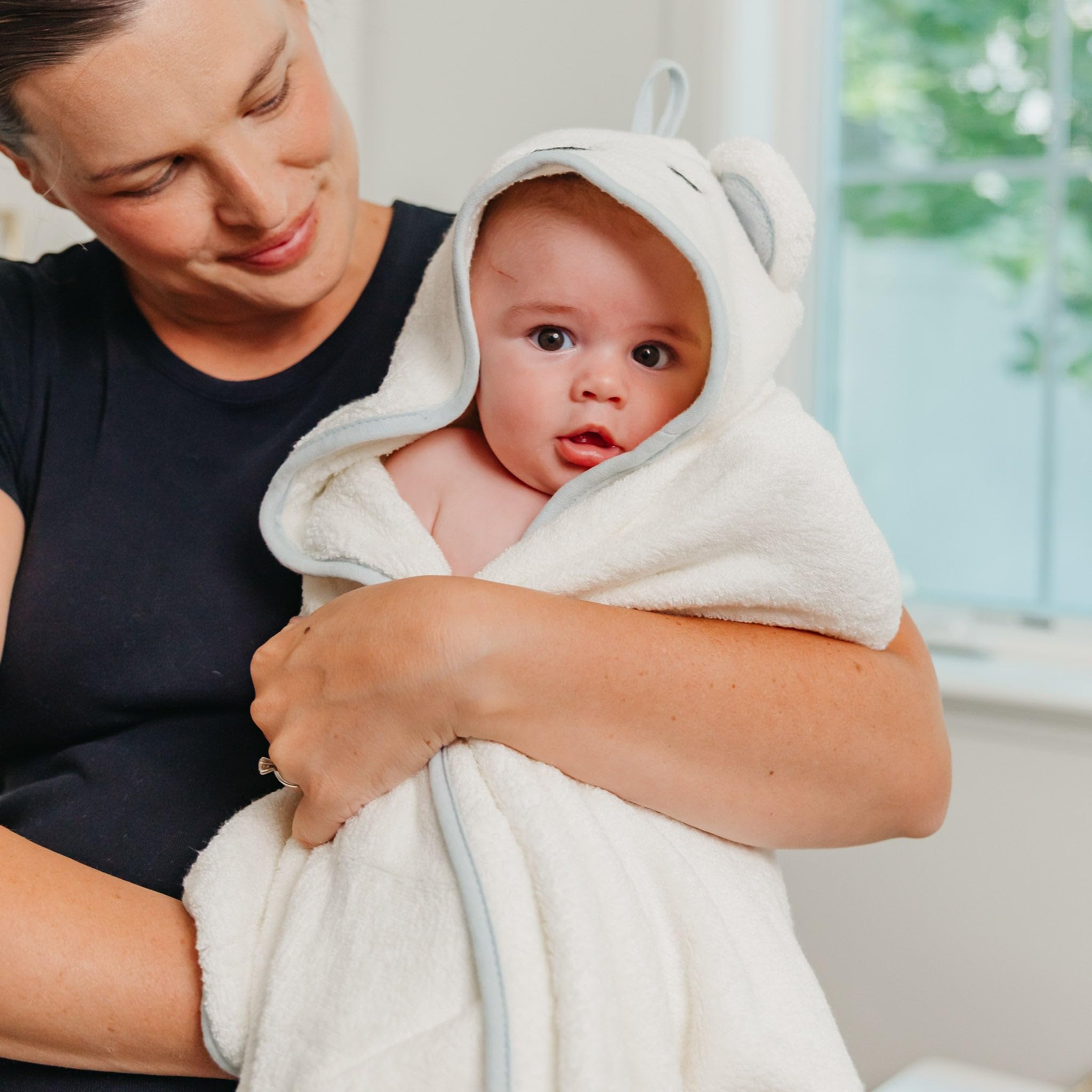 Copper Pearl Juno hooded towel displayed in a cozy nursery setup.