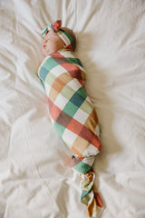 Copper Pearl Nicholas swaddle in use, snug and breathable for soothing newborn moments