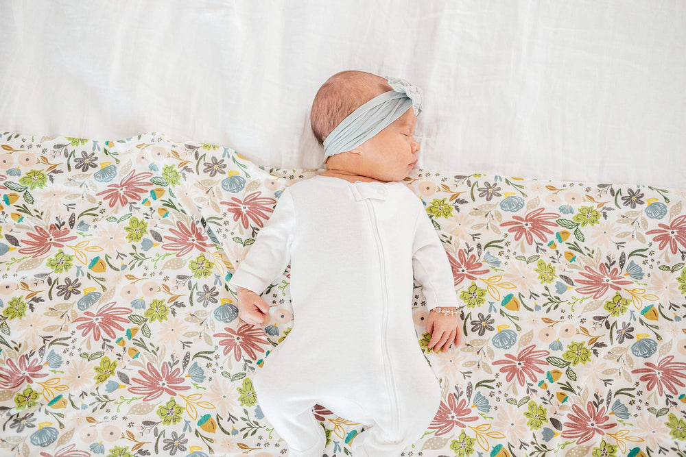 Copper Pearl olive baby resting on blanket, cozy nap-time companion.