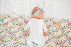 Copper Pearl olive baby resting on blanket, cozy nap-time companion.