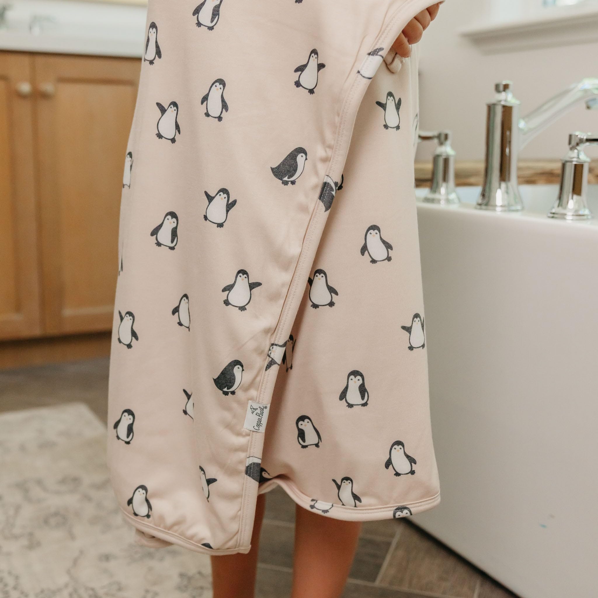 Copper Pearl Penguins hooded towel features durable knit exterior for lasting softness.