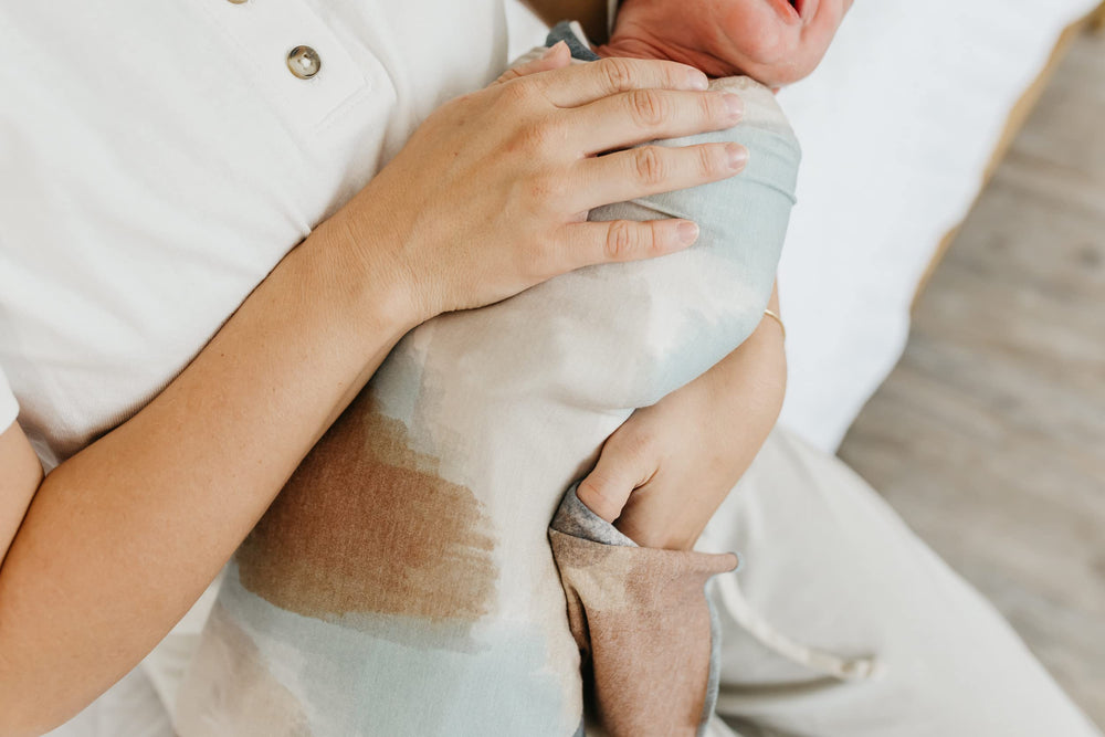Copper Pearl Picasso large swaddle blanket used for tummy time on the play mat