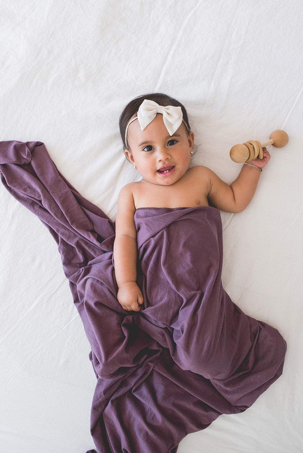 Copper Pearl plum swaddle blanket acts as stroller shield for travel days.