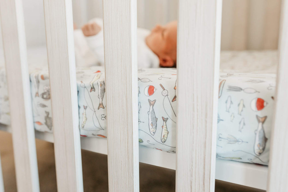 Copper Pearl Trout knit crib sheet on standard mattress in nursery