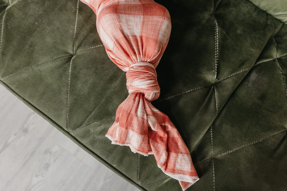 Copper Pearl Ralphie swaddle on display by model highlighting versatile design.