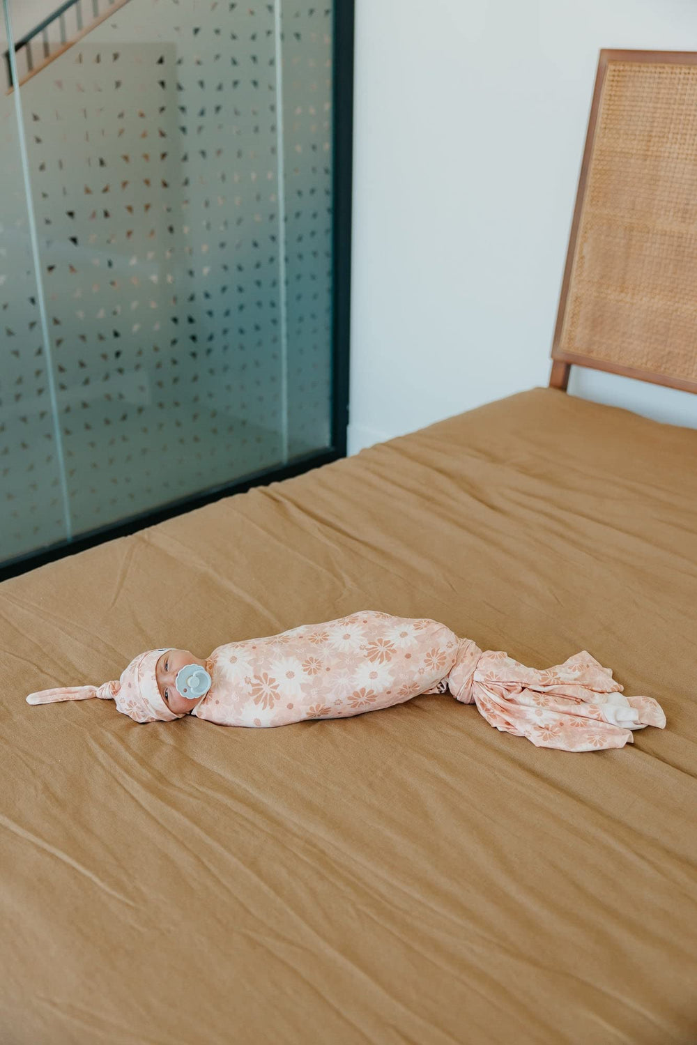Copper Pearl swaddle as stroller shield keeps baby comfortable during outdoor strolls.