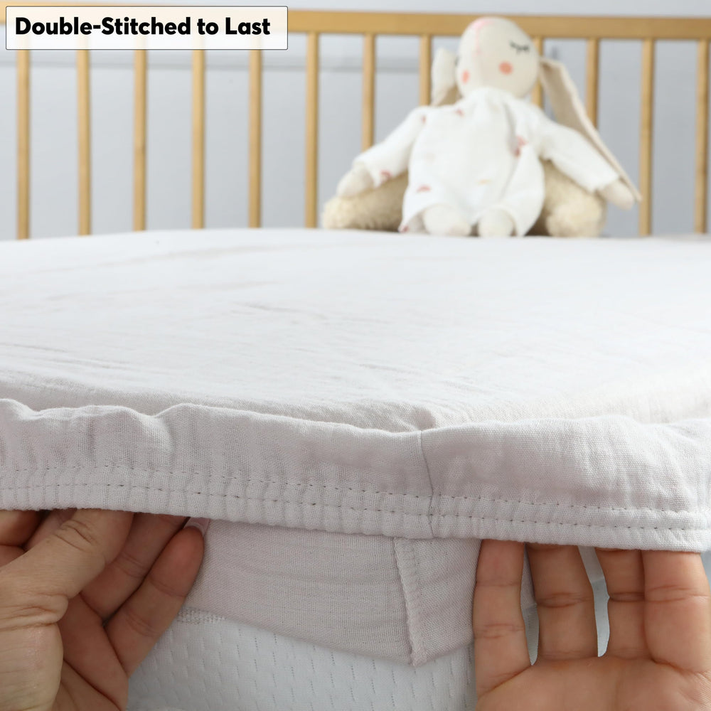 Cottonsis muslin crib sheet close-up reveals reinforced double-stitched edges for durability.