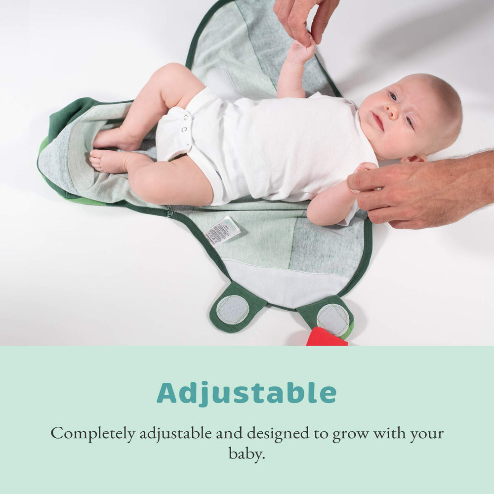 Cuddle Club swaddle on a sleeping newborn, signaling comfort and calm.