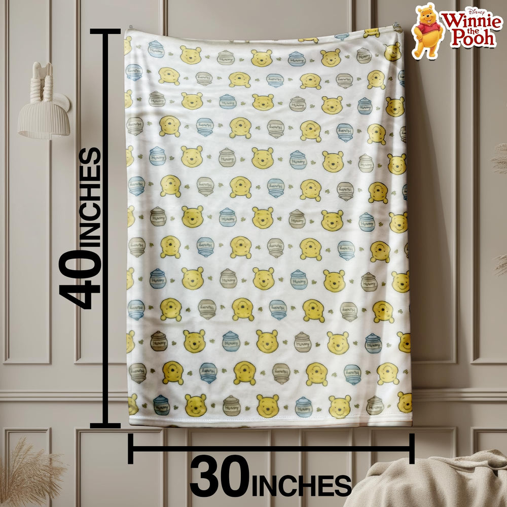 Cudlie Winnie the Pooh blanket multicolor design laid out as nursery decor and cuddles.
