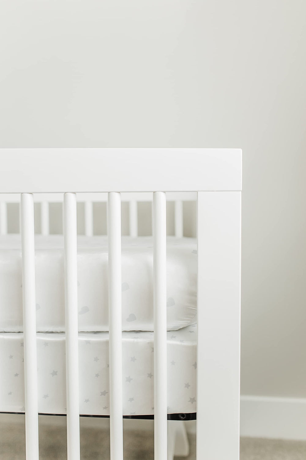 CutieCozy white satin crib sheet with gray hearts design.