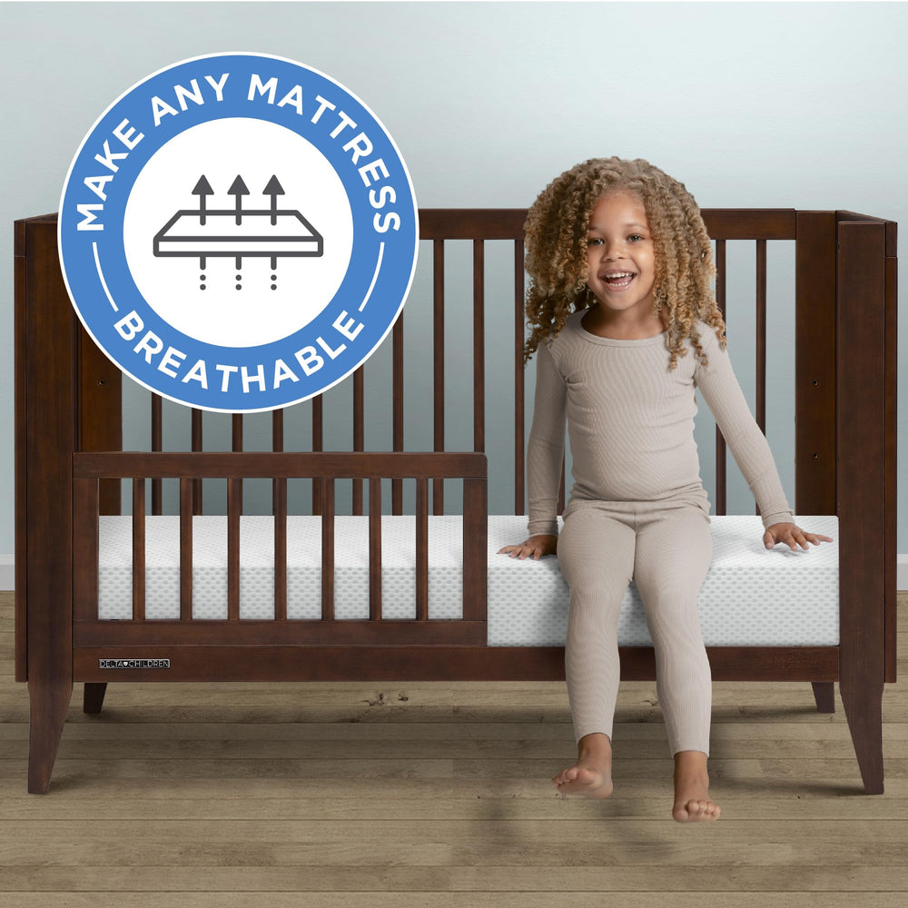 Delta Children breathable crib pad laid on a standard crib mattress showing universal fit.
