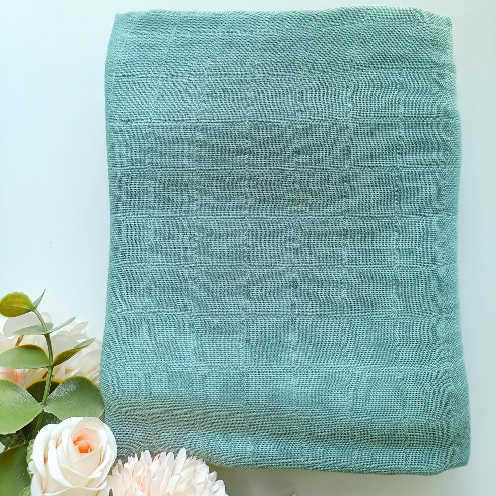 DEZIGKA sage green swaddle shown as receiving blanket for cozy newborn snuggles.