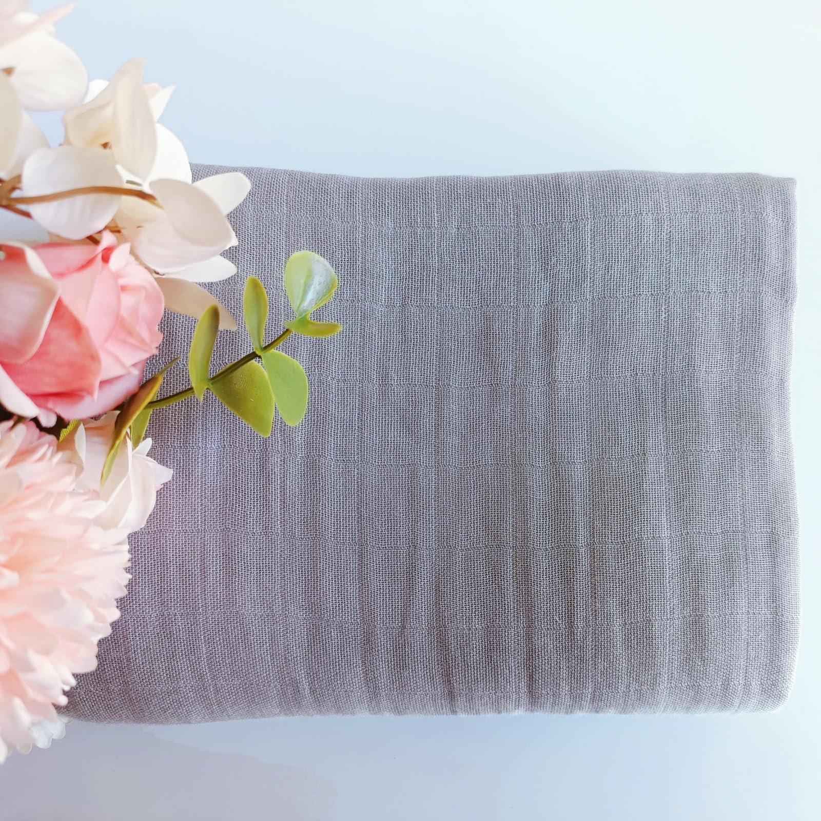 DEZIGKA nursery-ready swaddle shown as photography prop and stroller cover