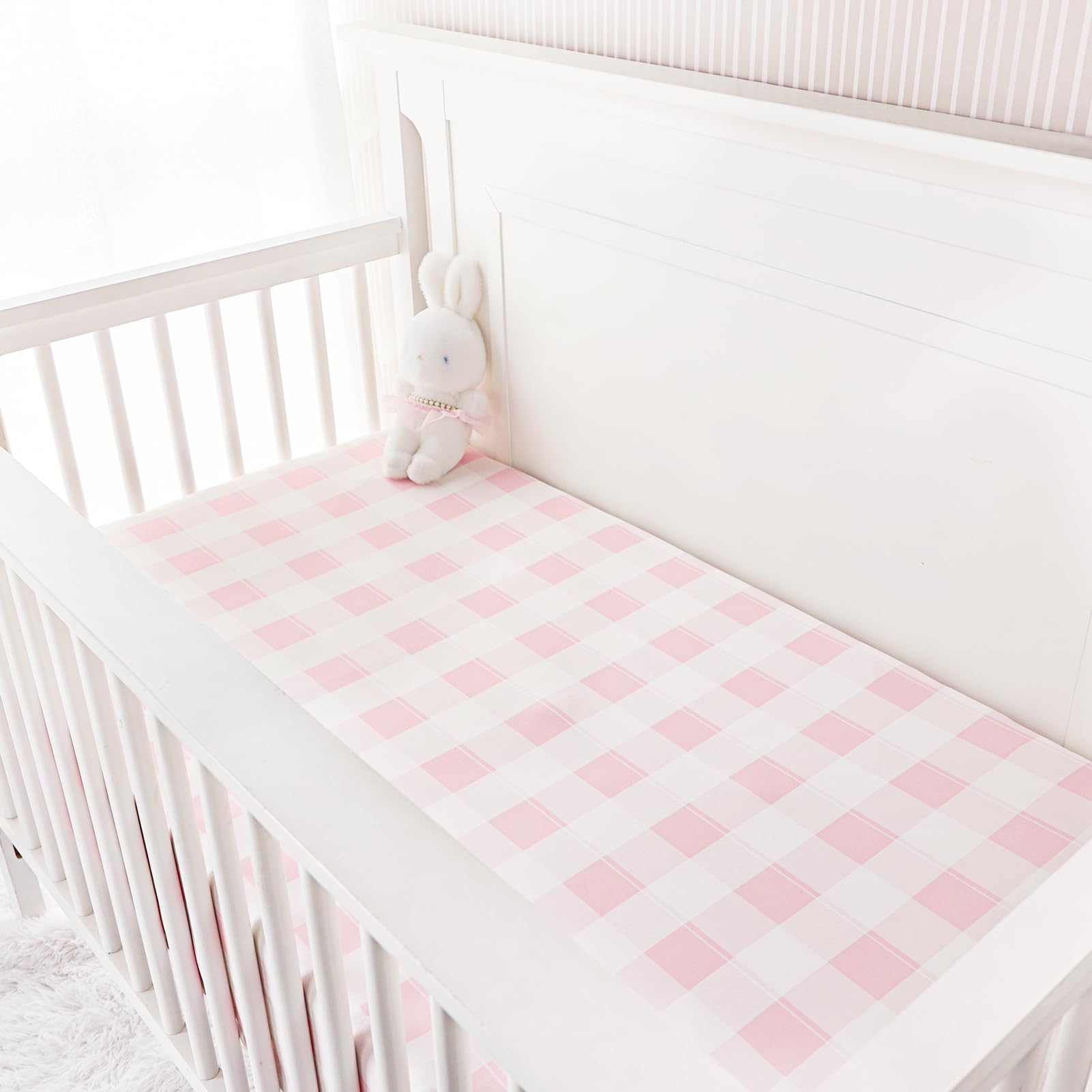 DILIMI pink checkered crib sheet on a standard crib showing fit