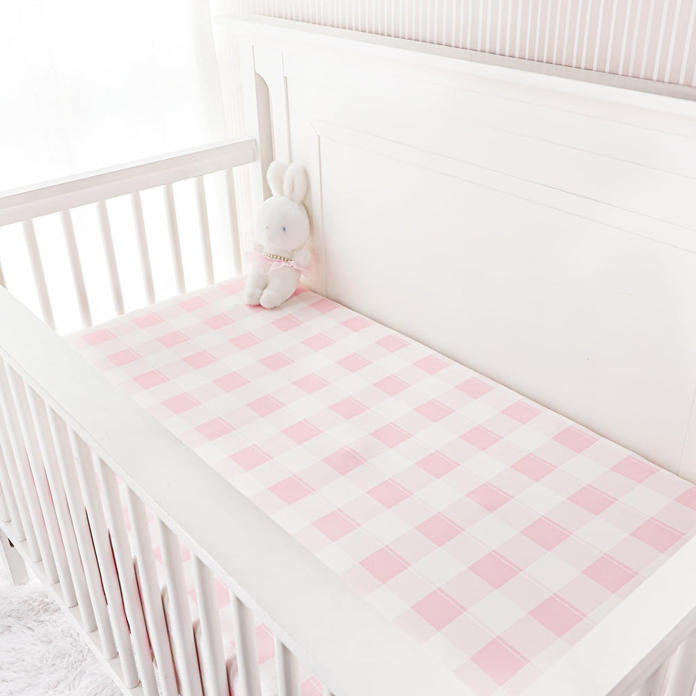 DILIMI pink checkered crib sheet on a standard crib showing fit
