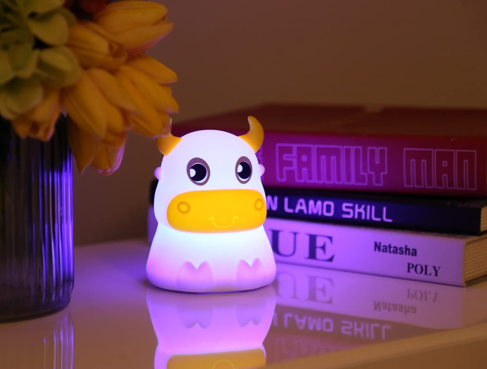 Dimanito cow night light, side view showing soft illumination in a nursery.