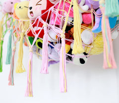 Diocos boho macrame toy hammock display adds cozy charm to a nursery.