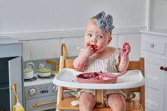 Dollop dusty rose suction plate on high chair tray helps keep mealtime tidy