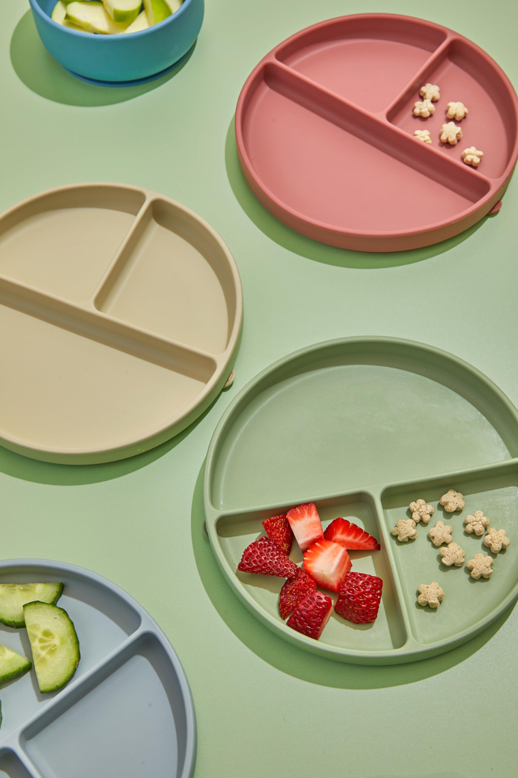 Dollop dusty rose suction plate with kid hands demonstrates self-feeding