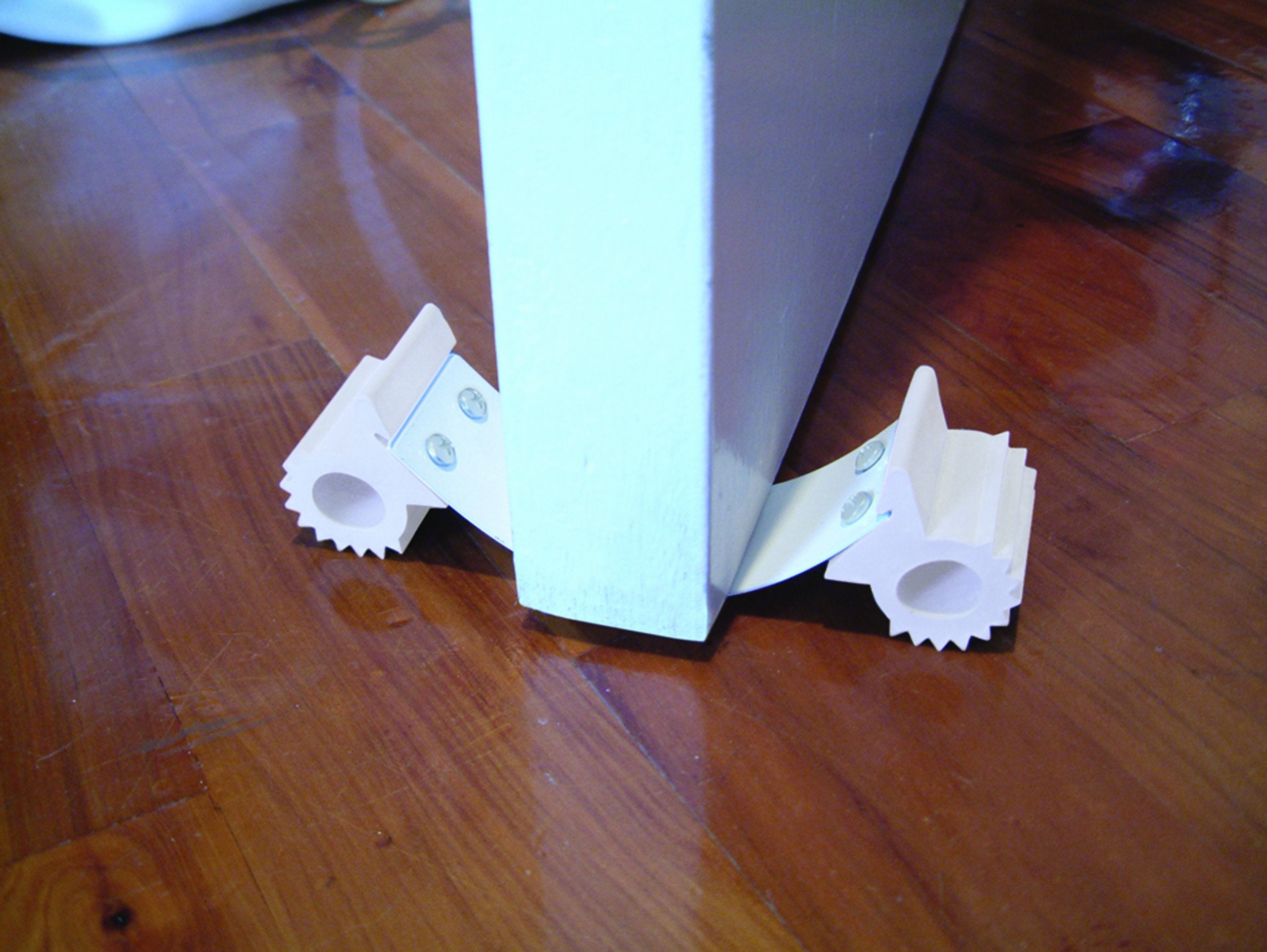 Dreambaby Under Door Gripper on tile floor keeps the door steady.