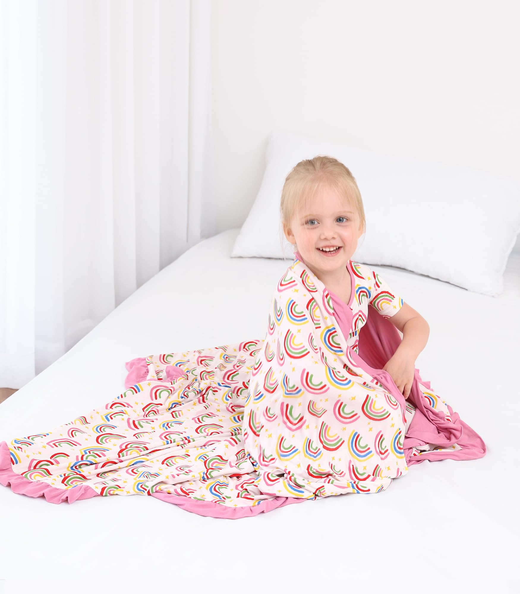 DREAMHALO rainbow blanket on bed showing nursery decor and warmth