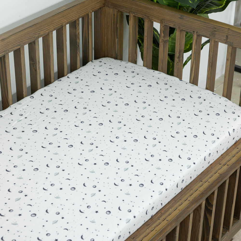 Dreamology Planets crib sheet on mattress demonstrates snug elastic-edge fit