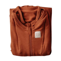 Elovee & Co. small rust swaddle wrapped around a tiny newborn for secure sleep