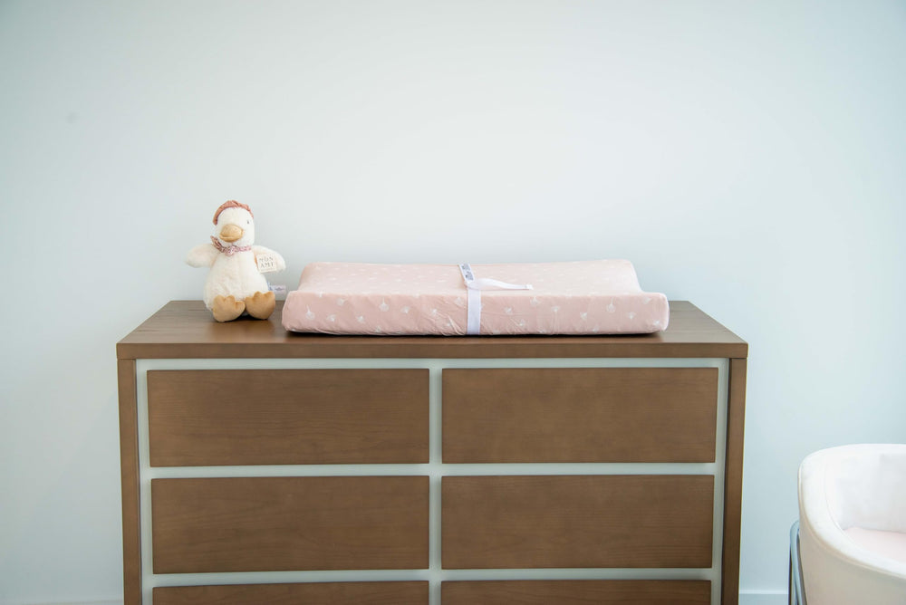 Rosewater pink palette enhances nursery decor with a cozy, comfortable changing surface.