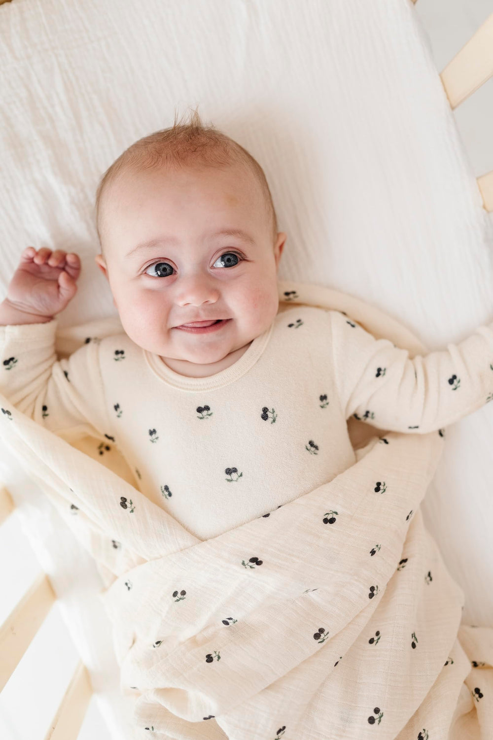 Gift-ready Ely's & Co. muslin swaddle blanket displayed with baby items
